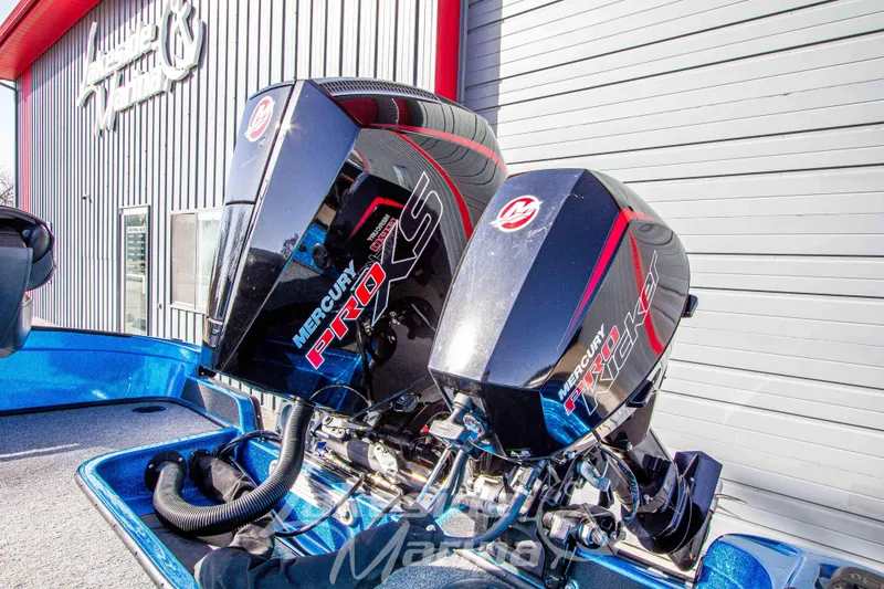 Slide: The Image of 2024 Recon 985 SC boat with dual Mercury Pro XS engines at a marina. - 12