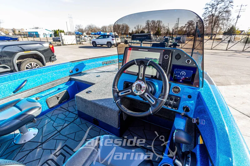 Slide: The Image of 2024 Recon 985 SC boat interior with steering wheel and navigation system at Lakeside Marina. - 20