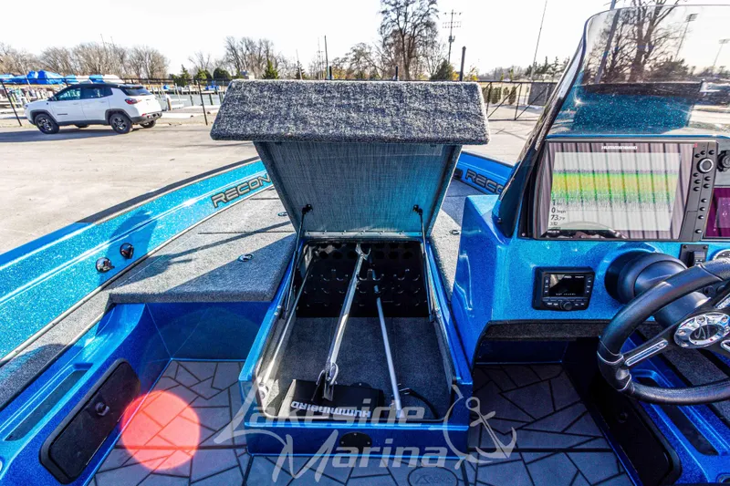 Slide: The Image of 2024 Recon 985 SC boat interior with open storage compartment and navigation display. - 29