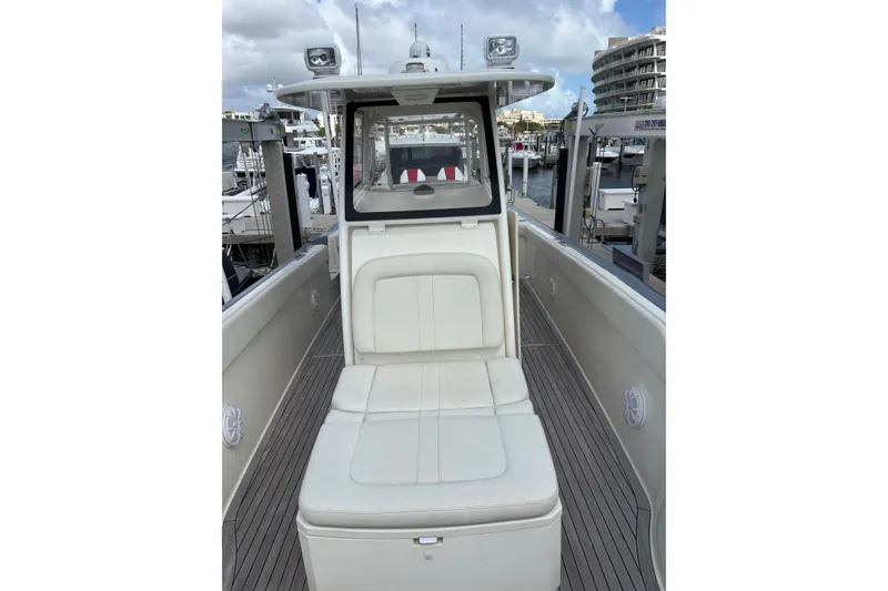 Slide: The Image of 2018 Ocean 1 R boat interior with white seating at a marina. - 13
