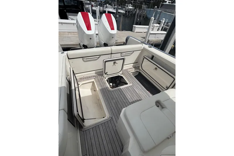 Slide: The Image of 2018 Ocean 1 R boat interior with open storage compartments and twin engines at dock. - 20