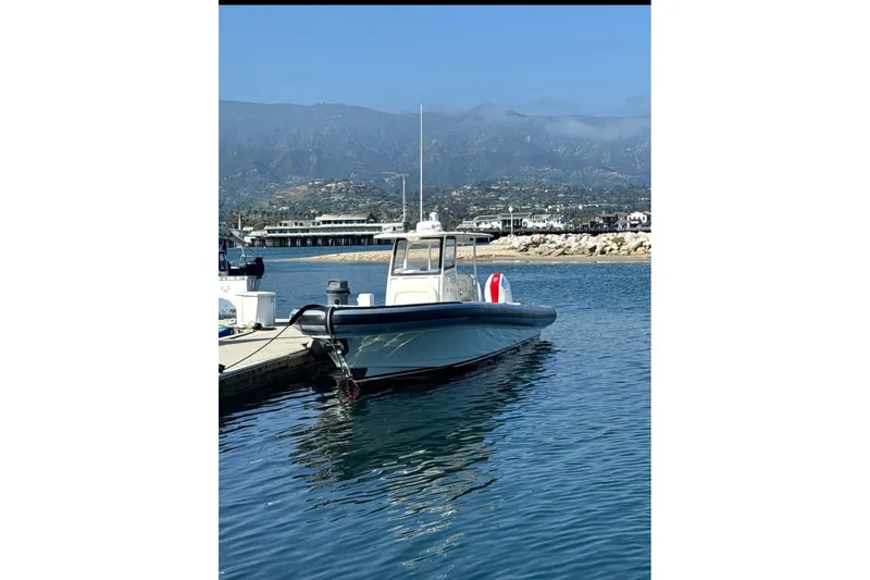 Slide: The Image of 2018 Ocean 1 R boat docked in a scenic marina with mountains in the background. - 3