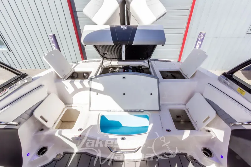 Slide: The Image of 2023 Chaparral 21 Surf boat interior with open storage compartments and engine view. - 19