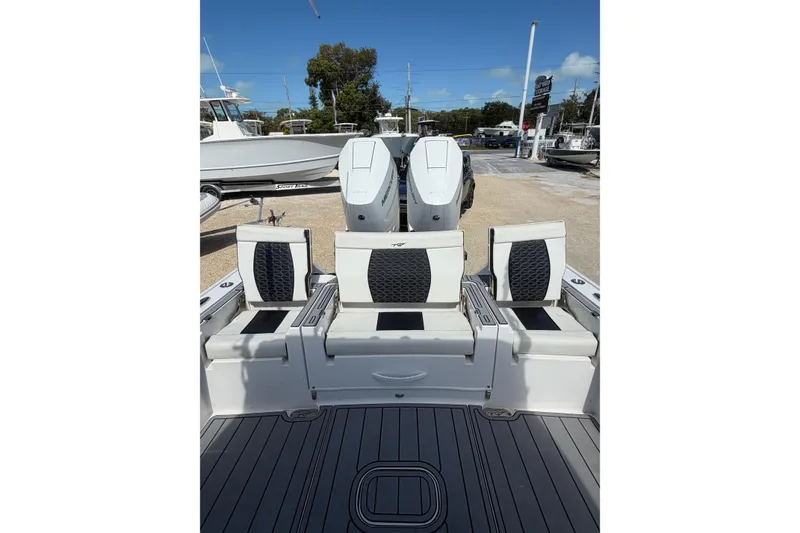 Slide: The Image of 2024 Tidewater 3100 Carolina Bay boat with seating and dual engines, docked outdoors. - 10
