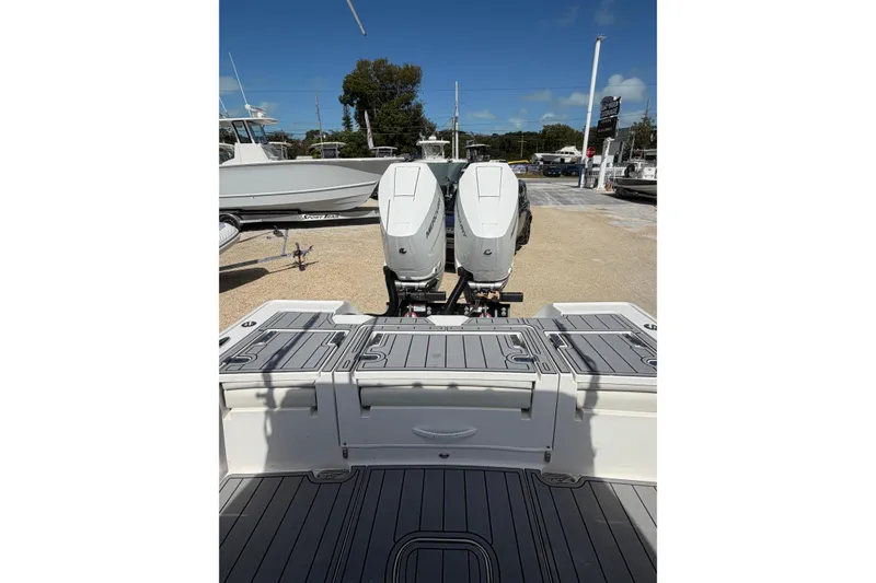 Slide: The Image of 2024 Tidewater 3100 Carolina Bay boat with dual outboard engines, docked outdoors. - 11