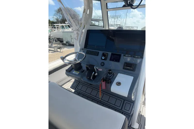 Slide: The Image of 2024 Tidewater 3100 Carolina Bay boat console with steering wheel and controls. - 14