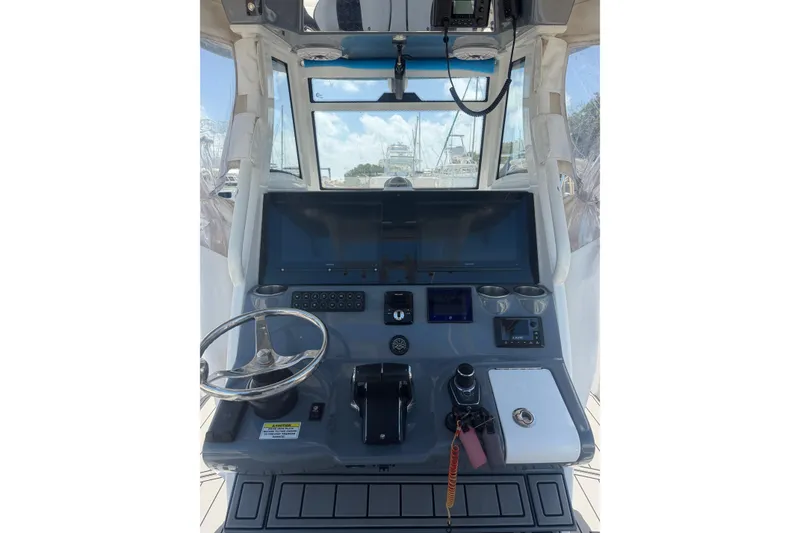 Slide: The Image of 2024 Tidewater 3100 Carolina Bay helm with modern controls and navigation display. - 15