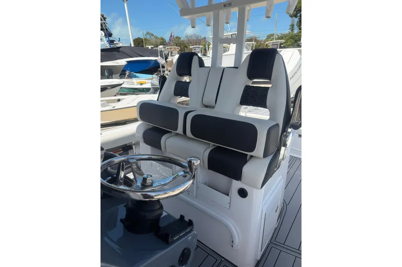 Slide: The Image of 2024 Tidewater 3100 Carolina Bay boat interior with dual seating and steering wheel. - 16