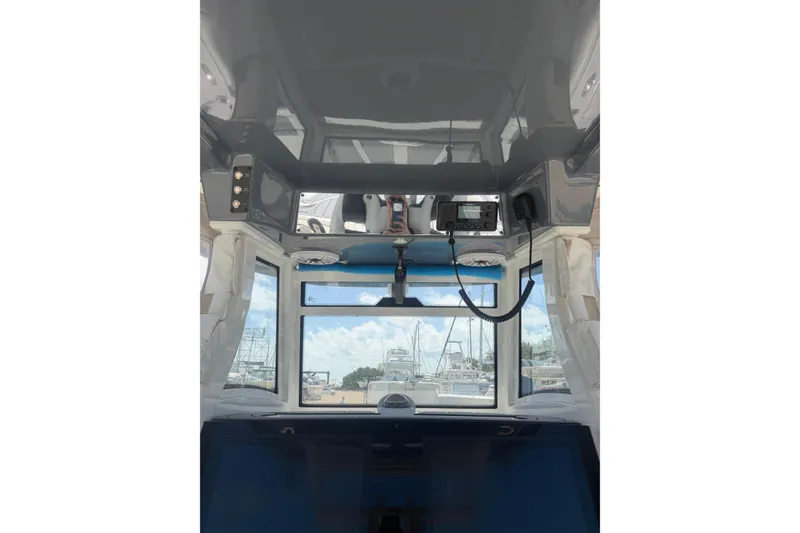 Slide: The Image of 2024 Tidewater 3100 Carolina Bay boat interior with navigation equipment and clear windows. - 18
