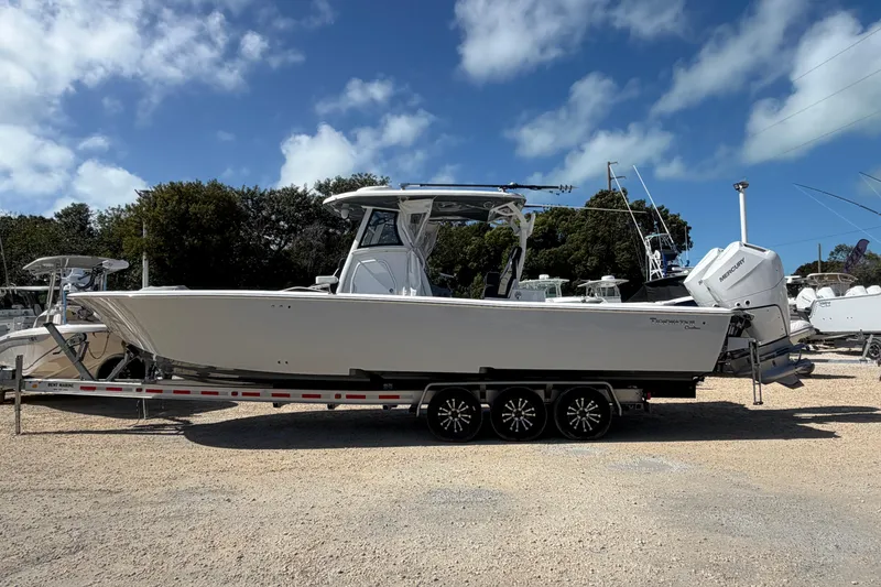 Slide: The Image of 2024 Tidewater 3100 Carolina Bay boat on trailer, parked outdoors under a blue sky. - 2