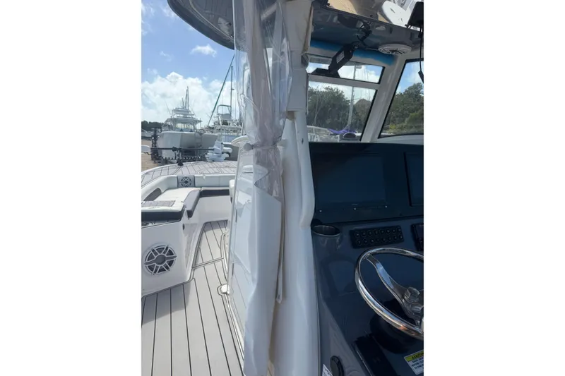 Slide: The Image of 2024 Tidewater 3100 Carolina Bay boat interior with steering wheel and seating area. - 21
