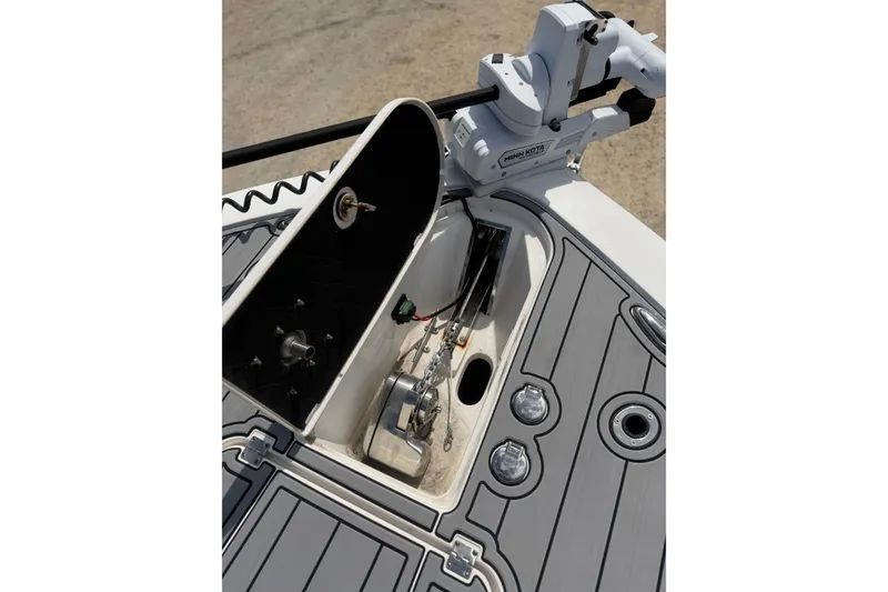Slide: The Image of 2024 Tidewater 3100 Carolina Bay boat deck with open storage compartment and Minn Kota trolling motor. - 27