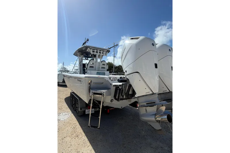 Slide: The Image of 2024 Tidewater 3100 Carolina Bay boat with dual outboard engines on a trailer. - 3