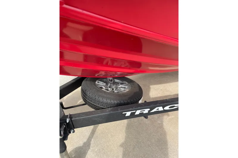 Slide: The Image of Red 2026 Tracker Pro Team 195 boat on trailer, showcasing wheel and hull detail. - 6