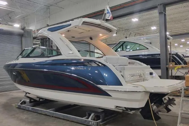 Slide: The Image of 2024 Formula 330 Crossover Bowrider I/O in showroom, blue and white design. - 2