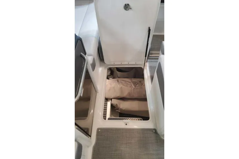 Slide: The Image of 2024 Formula 330 Crossover Bowrider I/O storage compartment with beige bags inside. - 39