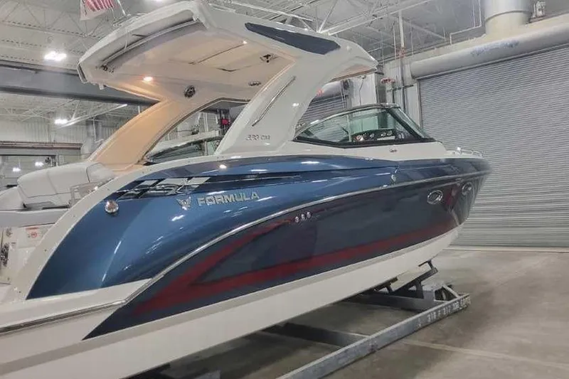 Slide: The Image of 2024 Formula 330 Crossover Bowrider I/O in showroom, sleek blue and white design. - 4