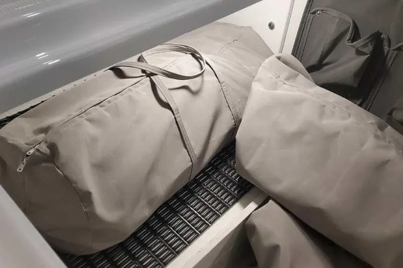 Slide: The Image of Storage compartment with bags in a 2024 Formula 330 Crossover Bowrider I/O boat. - 41