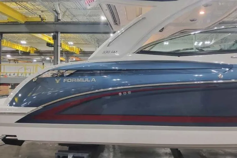 Slide: The Image of 2024 Formula 330 Crossover Bowrider I/O in a showroom, showcasing sleek design and blue exterior. - 5