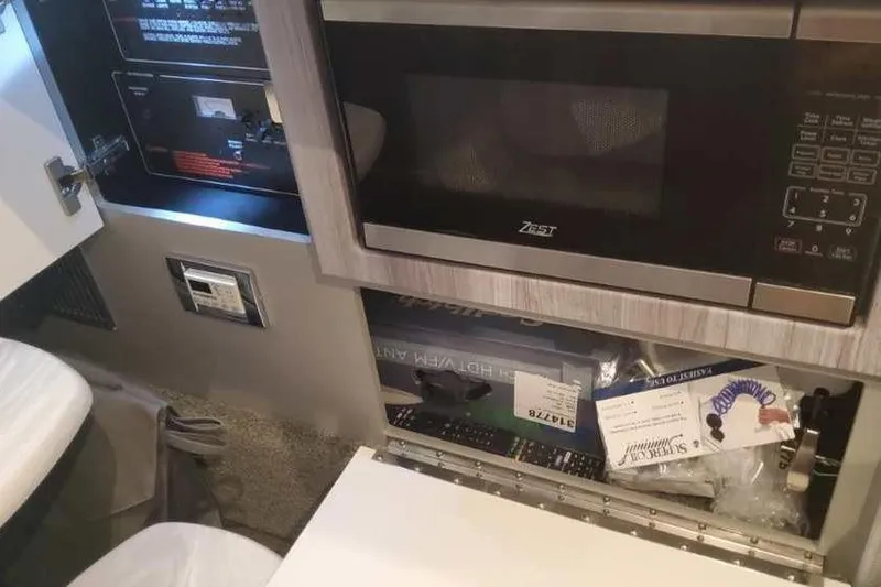 Slide: The Image of Interior of 2024 Formula 330 Crossover Bowrider I/O with microwave and storage area. - 50