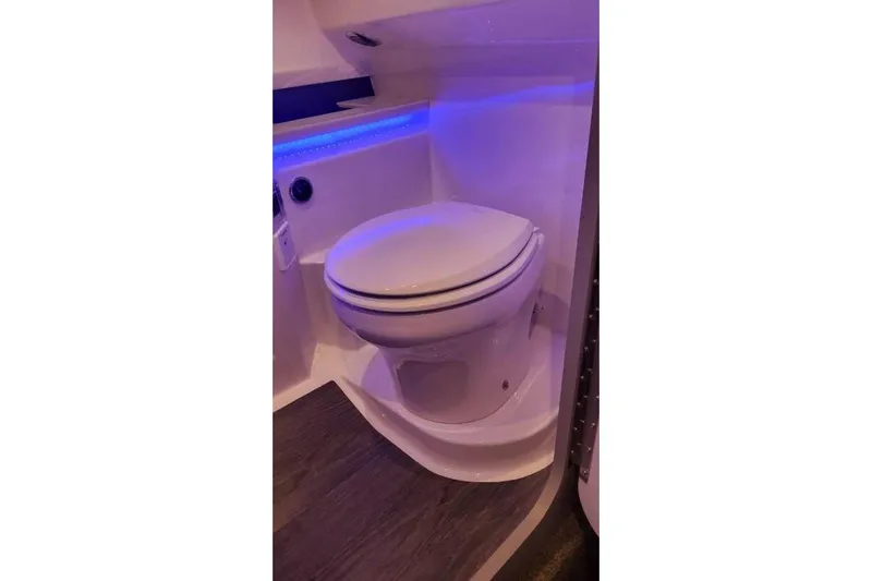 Slide: The Image of 2024 Formula 330 Crossover Bowrider I/O bathroom with modern toilet and ambient lighting. - 52