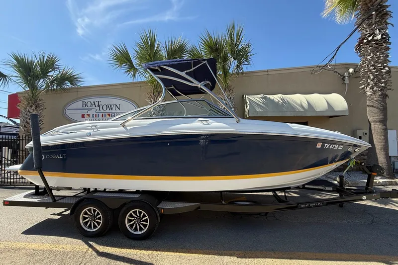 The Image of 2009 Cobalt 242 boat on trailer, parked at Boat Town dealership, sunny day. - 1