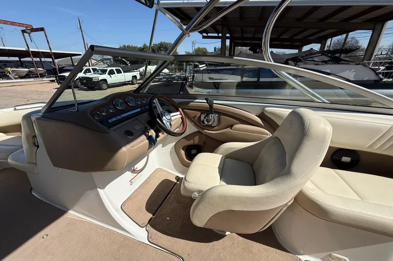 Slide: The Image of 2009 Cobalt 242 boat interior with beige seating and dashboard controls. - 10