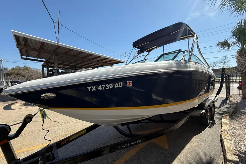 Slide: The Image of 2009 Cobalt 242 boat on trailer, blue and white, parked outdoors. - 4