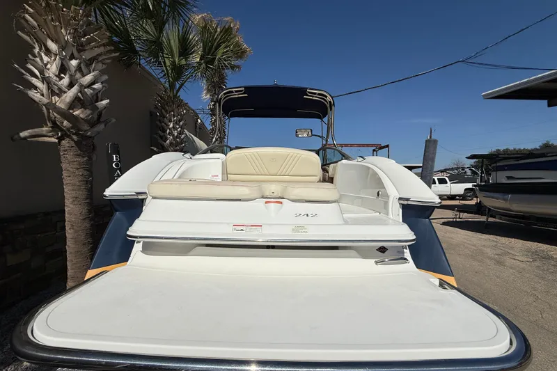 Slide: The Image of 2009 Cobalt 242 boat with seating, parked near palm trees under clear sky. - 7