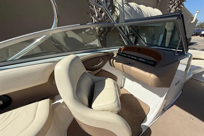 Slide: The Image of 2009 Cobalt 242 boat interior with beige seating and sleek dashboard design. - 9
