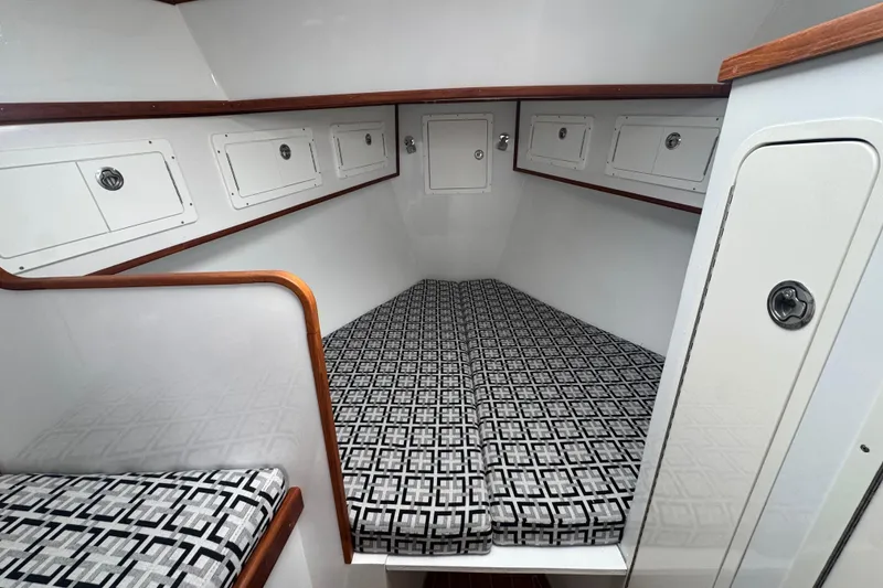 Slide: The Image of Interior cabin of 2000 Northern Bay 38, featuring patterned bedding and storage compartments. - 13