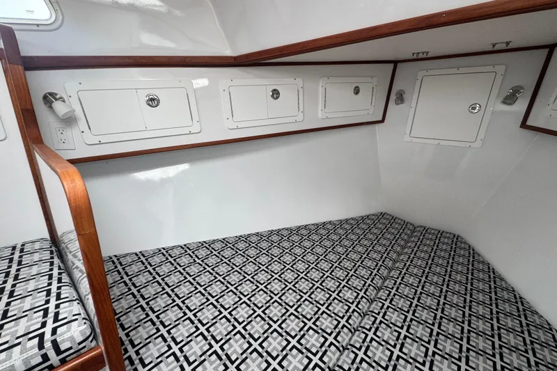 Slide: The Image of Interior cabin of 2000 Northern Bay 38 with patterned bedding and storage compartments. - 14