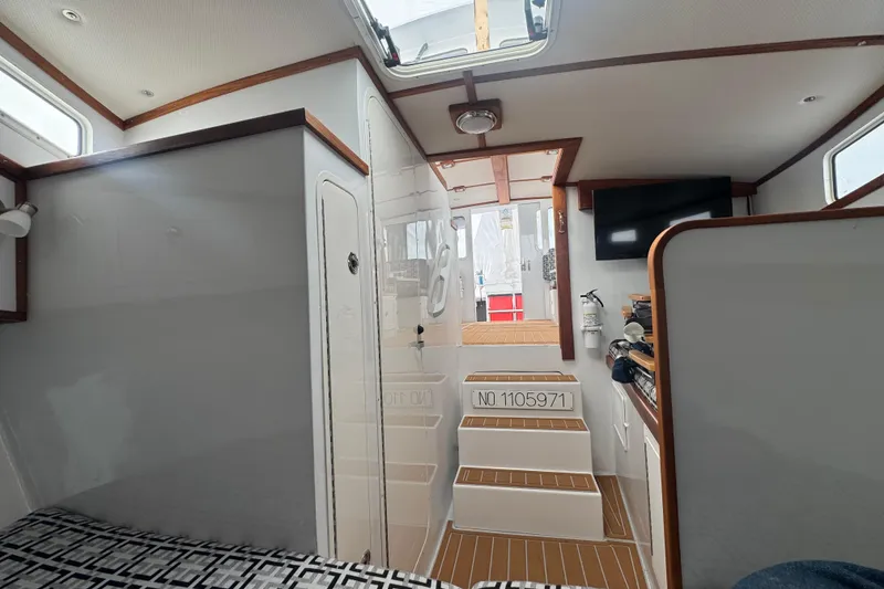 Slide: The Image of Interior of 2000 Northern Bay 38 boat, featuring stairs, wood accents, and a mounted TV. - 16