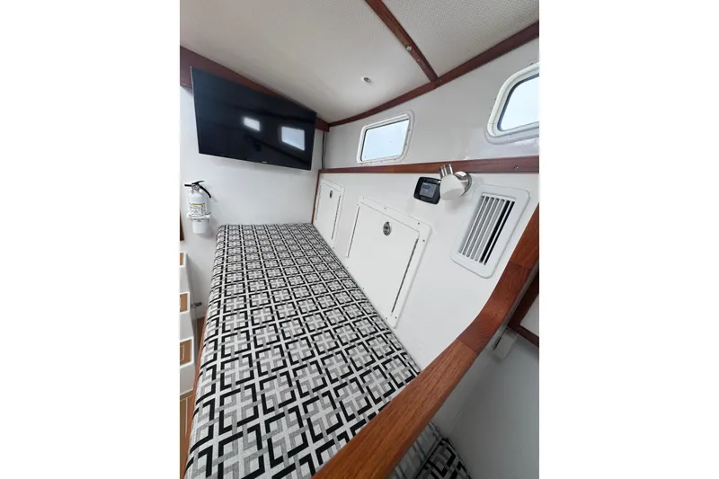 Slide: The Image of Interior of 2000 Northern Bay 38, featuring patterned bedding and mounted TV. - 17