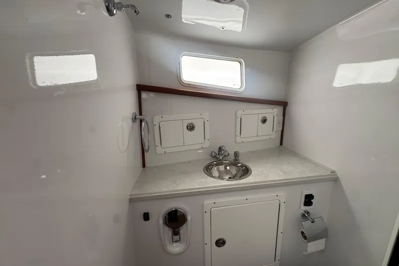 Slide: The Image of Compact bathroom in 2000 Northern Bay 38 boat with sink and storage cabinets. - 18