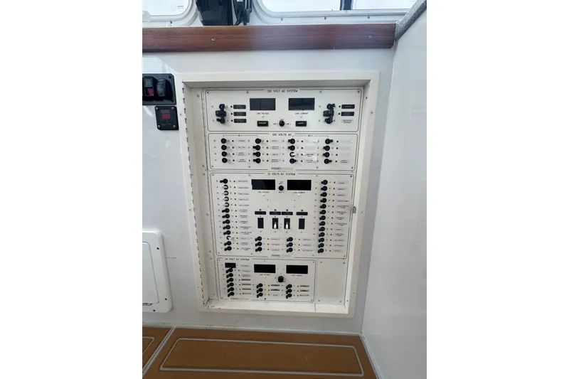 Slide: The Image of Electrical control panel on a 2000 Northern Bay 38 boat, featuring various switches and displays. - 19