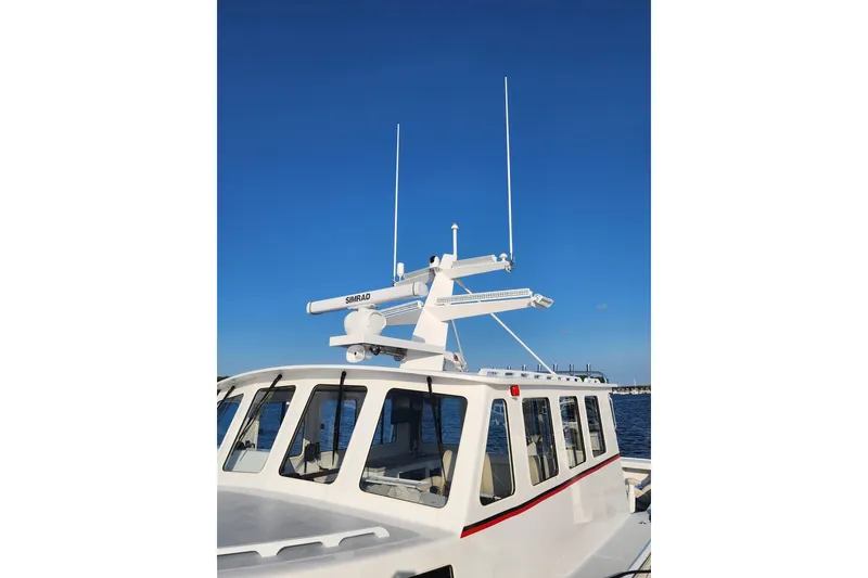 Slide: The Image of Northern Bay 36 Extended 38' Tuna rigged boat, rebuilt 2023, with radar equipment against clear blue sky. - 2