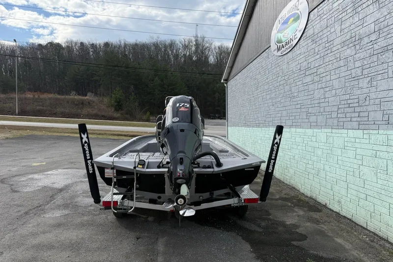 Slide: The Image of 2026 Xpress H22B Bay boat with 175 HP engine, parked outside a marine shop. - 3