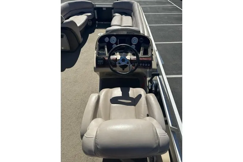 Slide: The Image of 2015 Regency 220 DL3 boat interior with steering console and beige seating. - 14