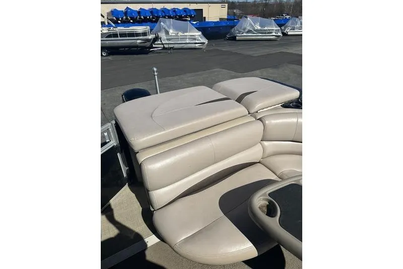 Slide: The Image of 2015 Regency 220 DL3 boat with beige seating, docked near covered boats. - 19