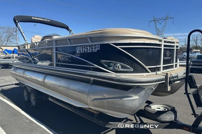 Slide: The Image of 2015 Regency 220 DL3 pontoon boat on trailer, parked outdoors. - 4