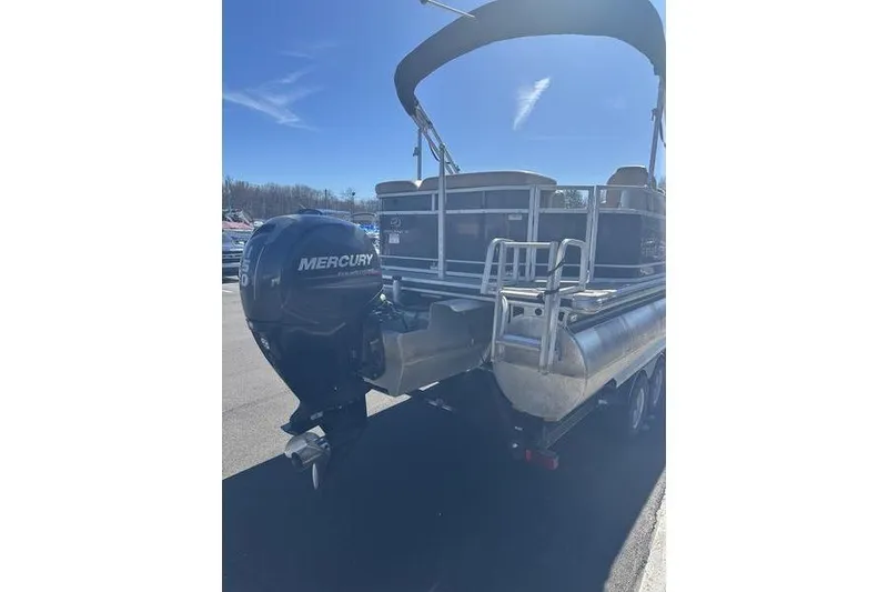 Slide: The Image of 2015 Regency 220 DL3 pontoon boat with Mercury outboard motor, parked outdoors. - 6
