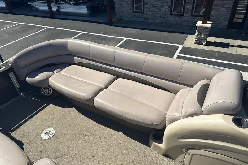 Slide: The Image of 2015 Regency 220 DL3 boat with beige seating in a parking area. - 7