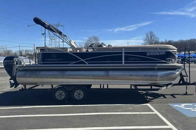 Slide: The Image of 2015 Regency 220 DL3 pontoon boat on trailer in parking lot. - 9