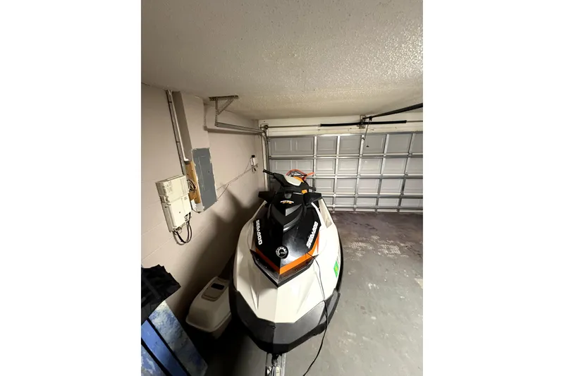 Slide: The Image of 2015 Sea-Doo GTS 130 jet ski parked in a garage. - 2