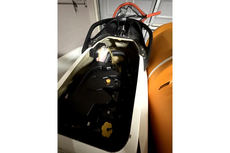 Slide: The Image of 2015 Sea-Doo GTS 130 engine compartment, partially open, in a garage setting. - 7