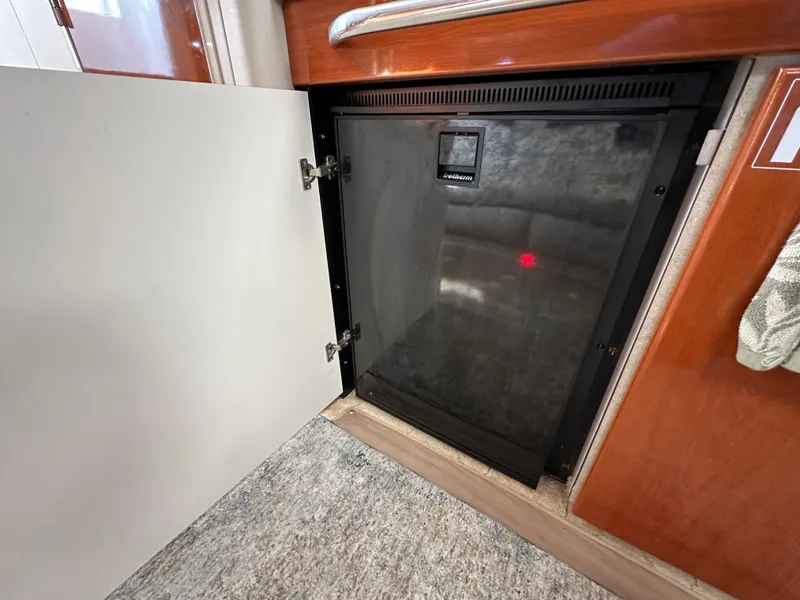 Slide: The Image of 2004 Formula 34 PC interior with open cabinet revealing a compact refrigerator. - 19