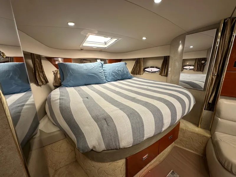 Slide: The Image of 2004 Formula 34 PC yacht cabin with striped bedding and blue pillows. - 21