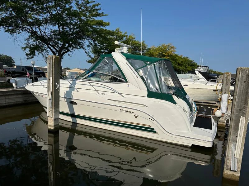 Slide: The Image of 2004 Formula 34 PC yacht docked in marina, featuring green accents and clear canopy. - 32