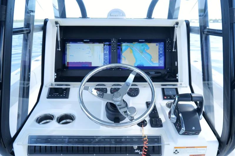 Slide: The Image of 2023 SeaVee 32 boat dashboard with dual navigation screens and steering wheel. - 21